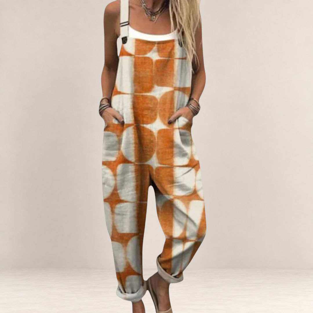 Valvet Oak House loose-fit jumpsuit in orange and white geometric print with adjustable straps and side pockets