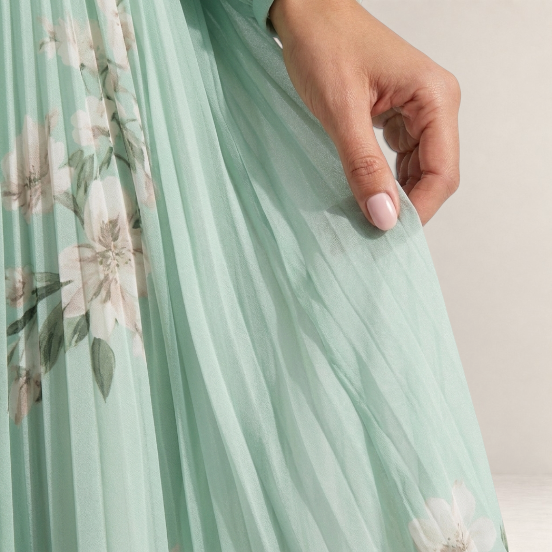Valvet Oak House Mel midi dress in light green pleated chiffon with a delicate floral pattern and flowing silhouette.