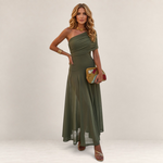 Valvet Oak House Chloe olive green one-shoulder maxi dress worn by a model with gold jewelry and a patterned clutch.