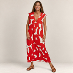 Valvet Oak House Thetis midi dress in red and white abstract print with V-neck, worn by a smiling woman in sandals.