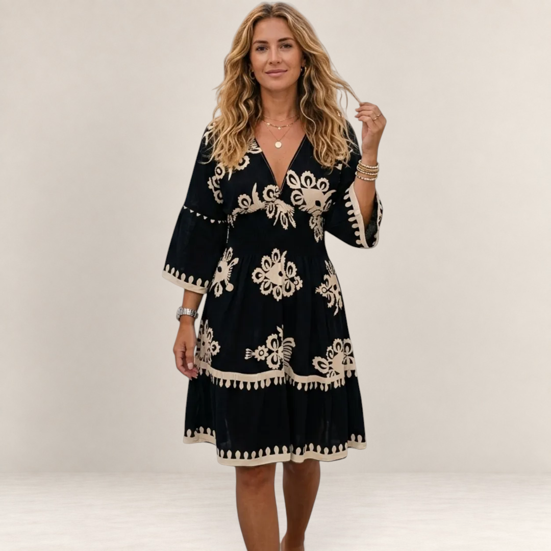 Valvet Oak House Hestia boho dress in black with cream floral embroidery, featuring a V-neck and flared sleeves.