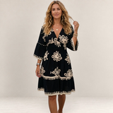 Valvet Oak House Hestia boho dress in black with cream floral embroidery, featuring a V-neck and flared sleeves.