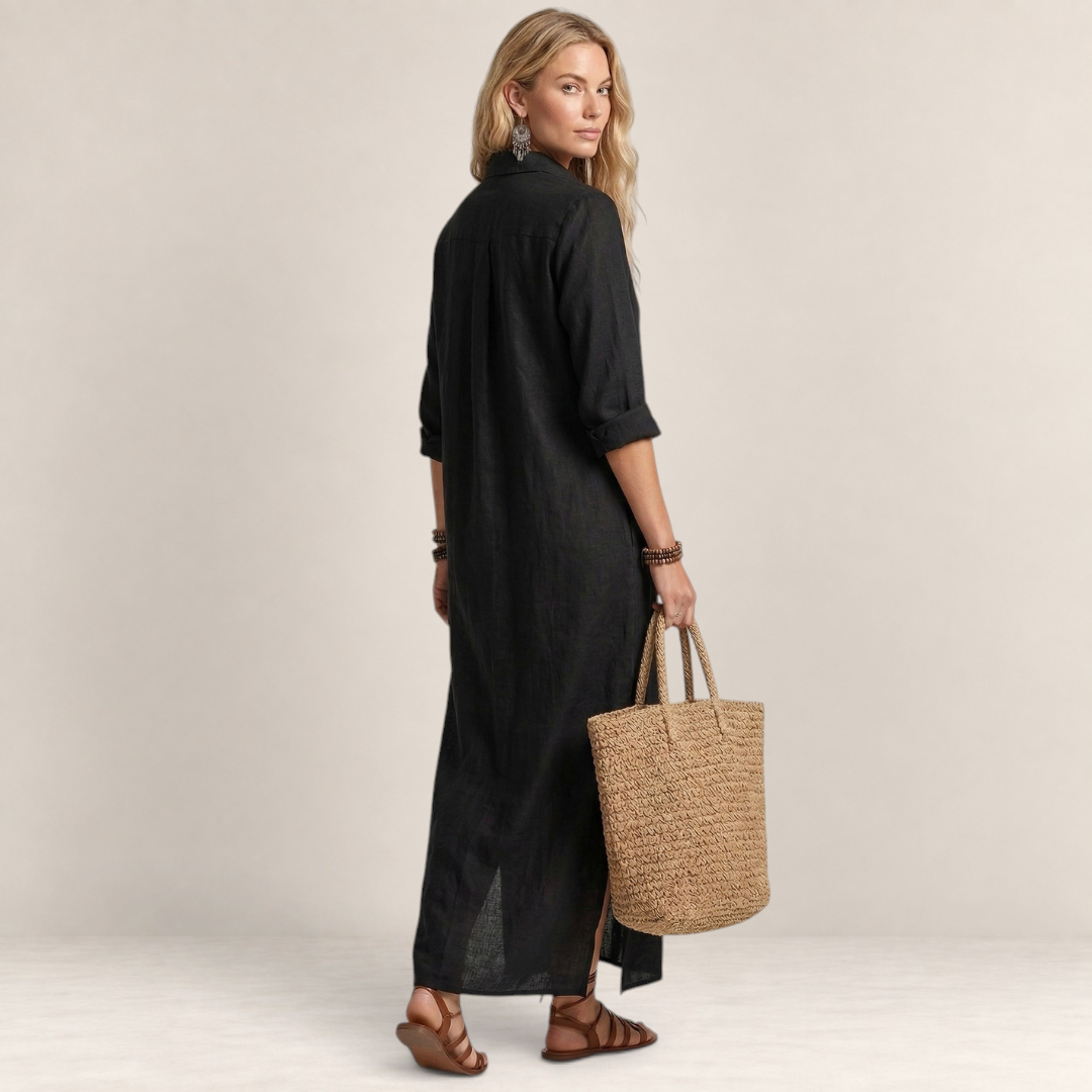 Valvet Oak House black maxi shirt dress with button-down front, worn by a blonde model holding a woven straw tote bag.