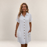 Valvet Oak House white button-down summer dress with short sleeves and pockets worn by a woman on a cobblestone street