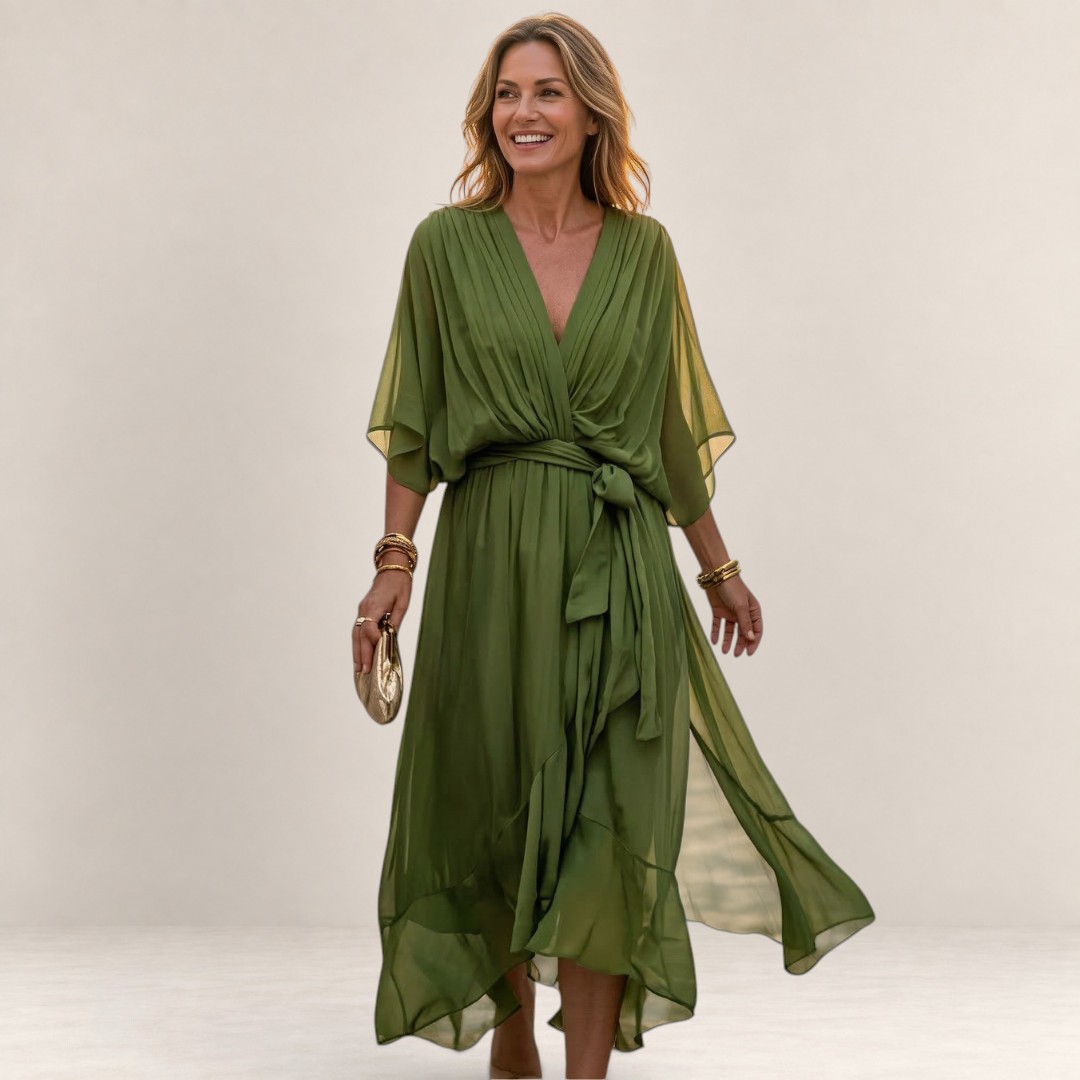 Valvet Oak House olive green flowy midi dress with V-neck and waist tie worn by a woman on a cobblestone street