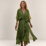 Valvet Oak House olive green flowy midi dress with V-neck and waist tie worn by a woman on a cobblestone street