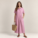 Valvet Oak House pink cotton shirt dress with button-down front and pleated detail worn by a model with a straw bag