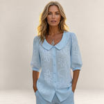Valvet Oak House light blue floral button-down shirt with a rounded collar worn by a woman with blonde hair