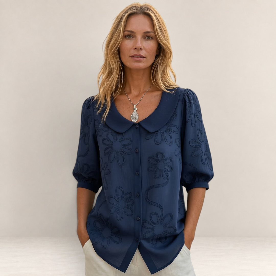 Valvet Oak House Marina navy blue floral embroidered blouse with a Peter Pan collar worn by a blonde woman