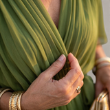 Valvet Oak House Helena olive green pleated V-neck dress with soft flowing fabric and gold bangle bracelets