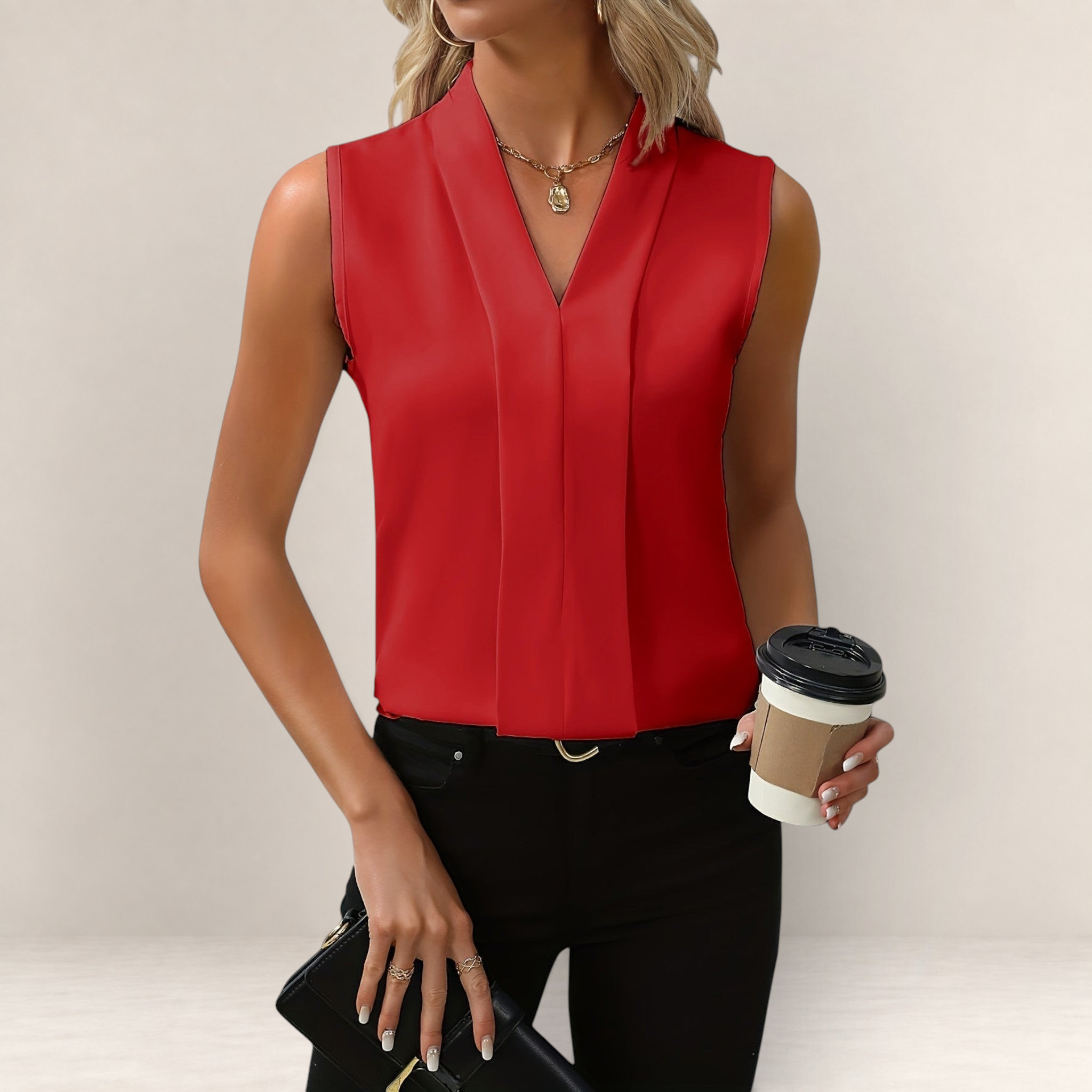 Valvet Oak House red sleeveless blouse with a deep V-neckline and relaxed, flowing fit worn with black trousers.