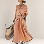 Valvet Oak House Mila peach midi dress with V-neck, waist knot detail, and black contrast trim on a model