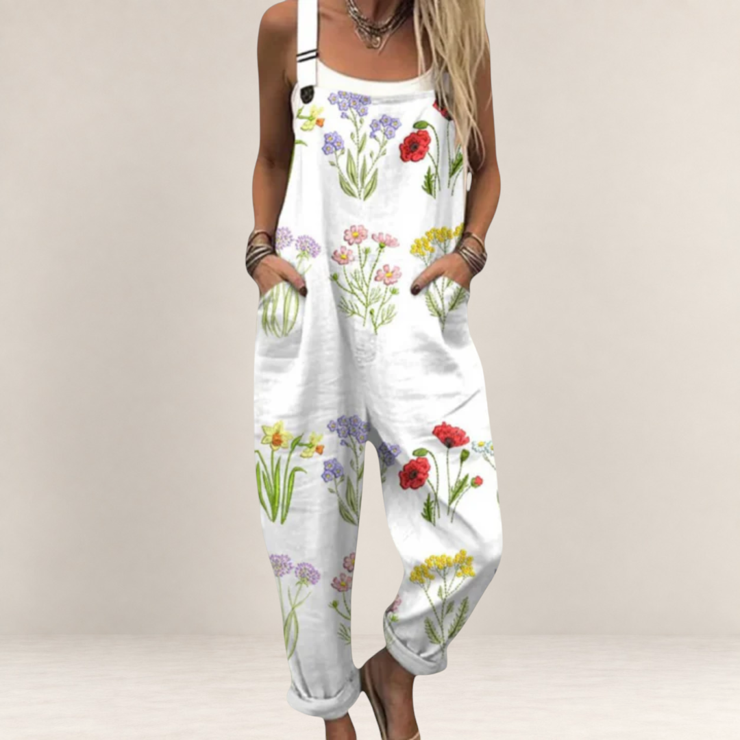 Valvet Oak House white floral print jumpsuit with wide legs, adjustable straps, and side pockets on a woman.