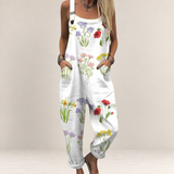 Valvet Oak House white floral print jumpsuit with wide legs, adjustable straps, and side pockets on a woman.