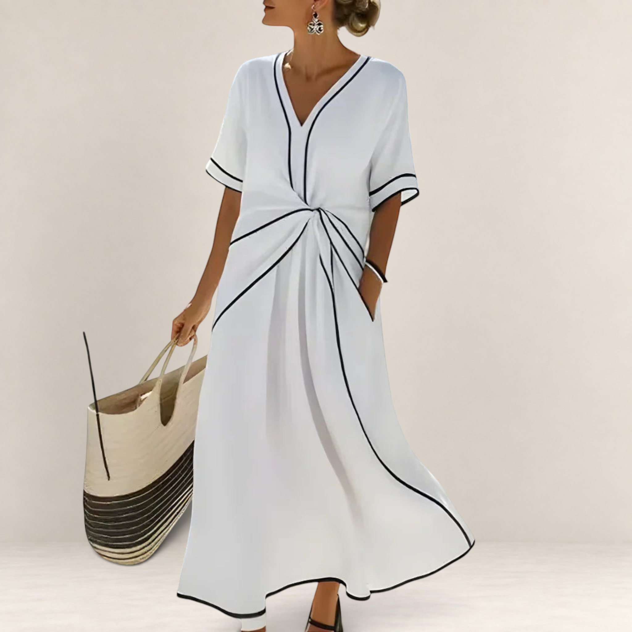 Valvet Oak House Mila white midi dress with V-neck, black contrast trim, and waist detail, worn by a woman by the sea.