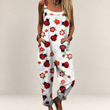 Valvet Oak House white jumpsuit with red ladybug and flower print, featuring a loose fit and adjustable straps.