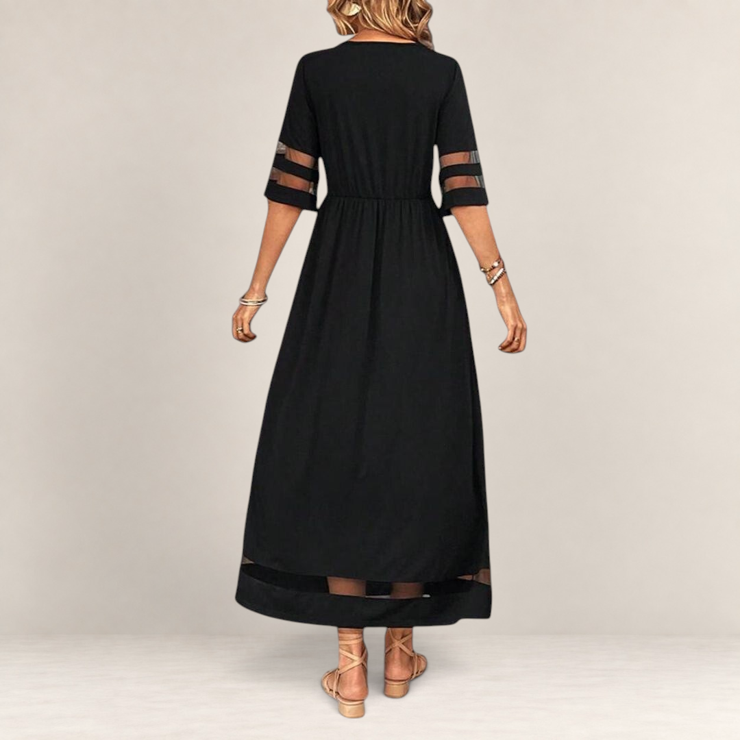 Valvet Oak House black midi dress with sheer mesh sleeve and hem panels, featuring an empire waist and flowing fit.
