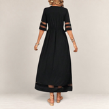 Valvet Oak House black midi dress with sheer mesh sleeve and hem panels, featuring an empire waist and flowing fit.