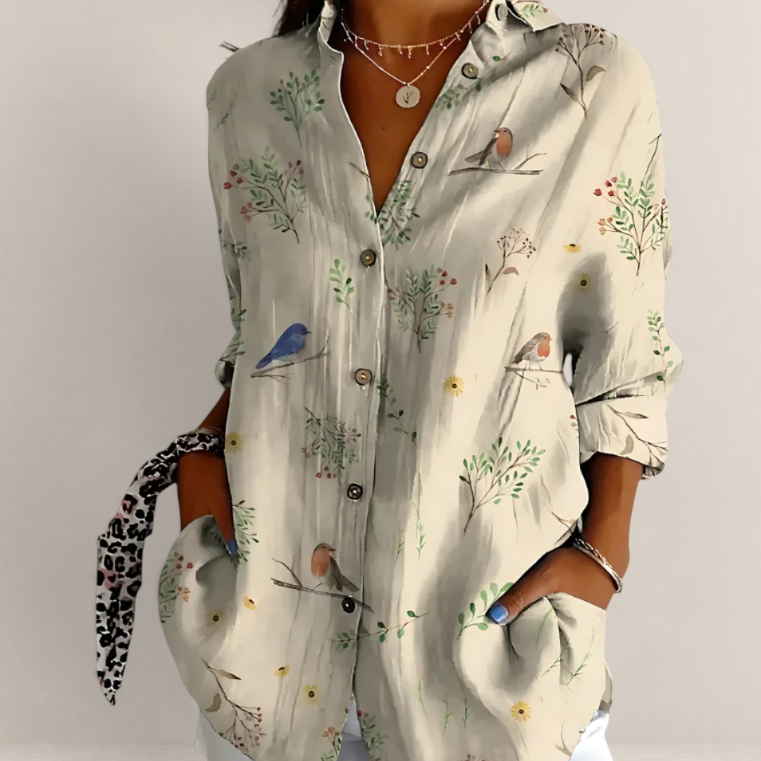 Valvet Oak House beige button-down blouse with bird and floral print, V-neck, and long sleeves on a woman
