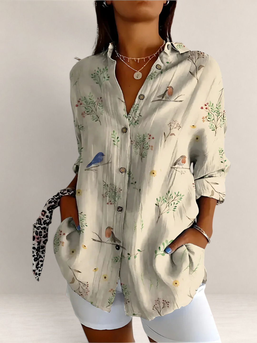 Valvet Oak House beige button-down blouse with bird and floral print, V-neck, and long sleeves on a woman