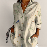 Valvet Oak House beige button-down blouse with bird and floral print, V-neck, and long sleeves on a woman