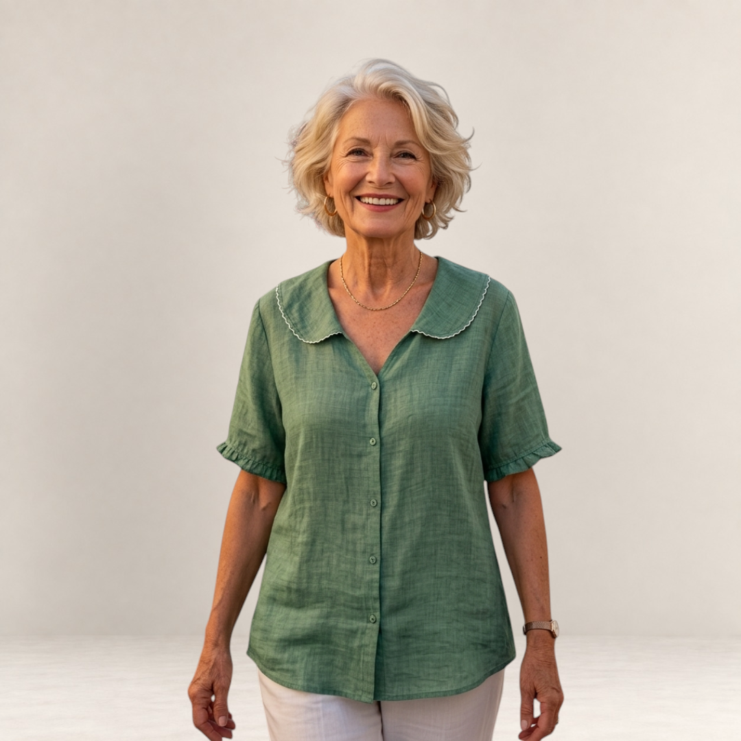 Valvet Oak House Pietra green cotton blouse with a scalloped collar worn by a smiling woman against a neutral wall