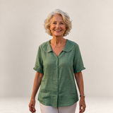 Valvet Oak House Pietra green cotton blouse with a scalloped collar worn by a smiling woman against a neutral wall