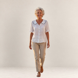 Valvet Oak House light cotton blouse with a wavy collar, worn by a smiling woman with beige trousers and sandals.