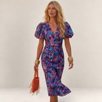 Valvet Oak House Cleide midi dress with V-neck, puff sleeves, and vibrant blue and pink abstract print on a model.