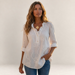 Valvet Oak House Larissa white floral embroidered blouse with a ruffled collar worn by a woman in a Greek village.