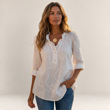 Valvet Oak House Larissa white floral embroidered blouse with a ruffled collar worn by a woman in a Greek village.