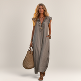 Valvet Oak House long grey linen-blend boho dress with ruffles and side pockets worn by a woman on a sunny street
