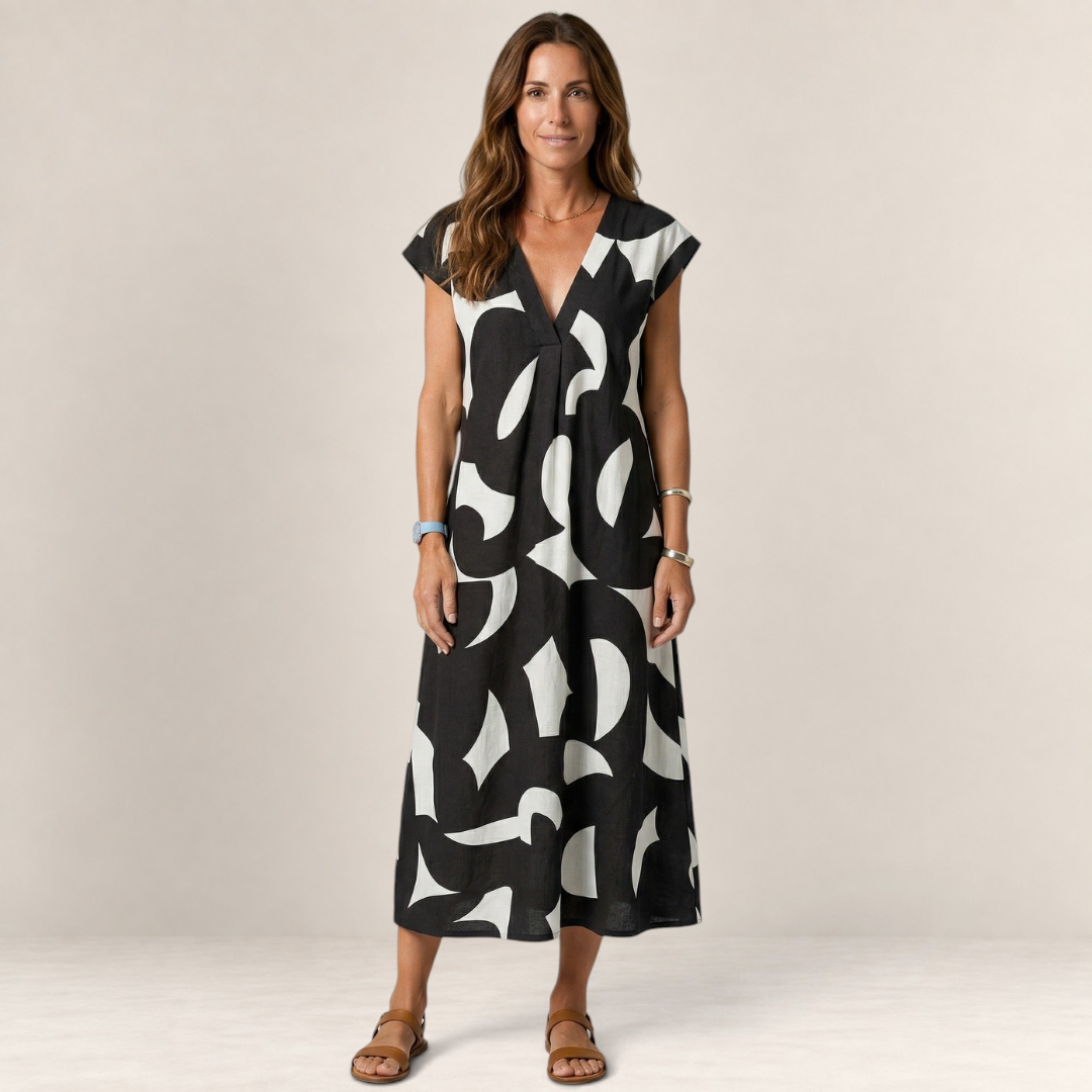 Valvet Oak House Thetis midi dress in black and white abstract print with a V-neck, worn by a woman on a grey background