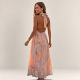 Valvet Oak House Stephanie silk maxi dress with halter neckline and floral watercolor print on a smiling model