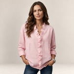 Valvet Oak House Elaine light pink linen blouse with ruffled V-neck worn by a woman with long wavy brown hair
