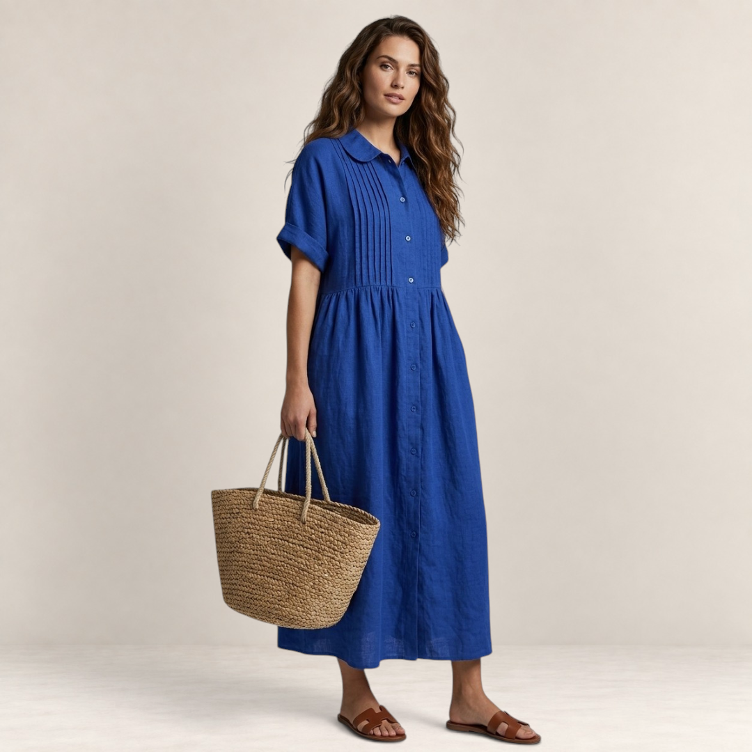 Valvet Oak House blue cotton shirt dress with pleated bodice and short sleeves worn by a woman with a straw bag