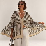 Valvet Oak House Thetis striped flowing blouse with V-neck worn by a smiling woman with sunglasses and pearl necklace