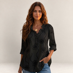 Valvet Oak House Larissa black blouse with floral embroidery and ruffled collar worn by a woman on a sunny street