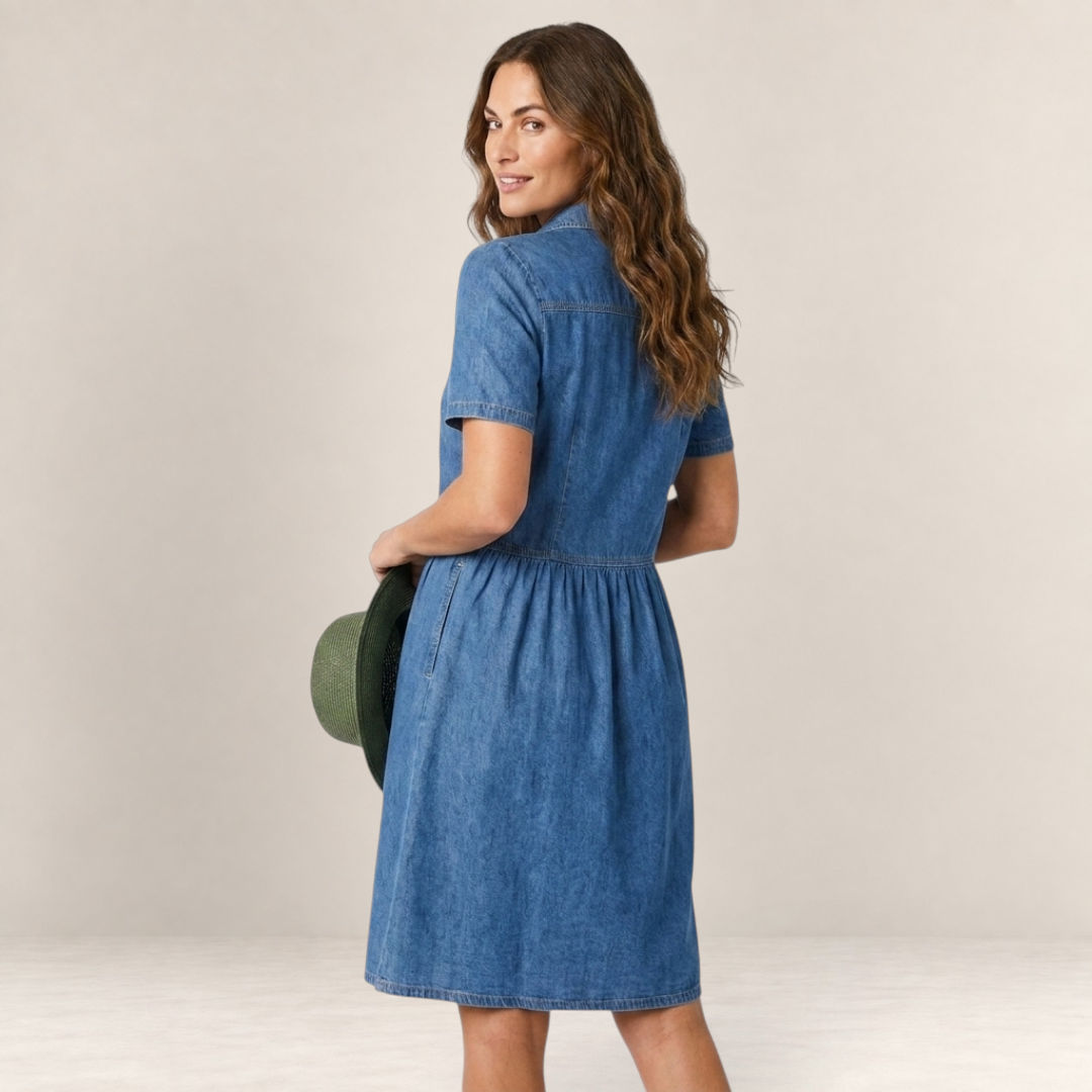 Valvet Oak House Neusa denim dress in blue with a flattering loose fit, worn by a woman holding a green hat