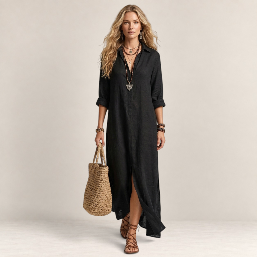 Valvet Oak House Afrodite black maxi shirt dress with button-down front, worn by a blonde model with a straw bag.