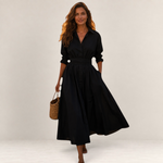Valvet Oak House Lana black cotton midi dress with a classic collar and long sleeves worn by a woman with a straw bag