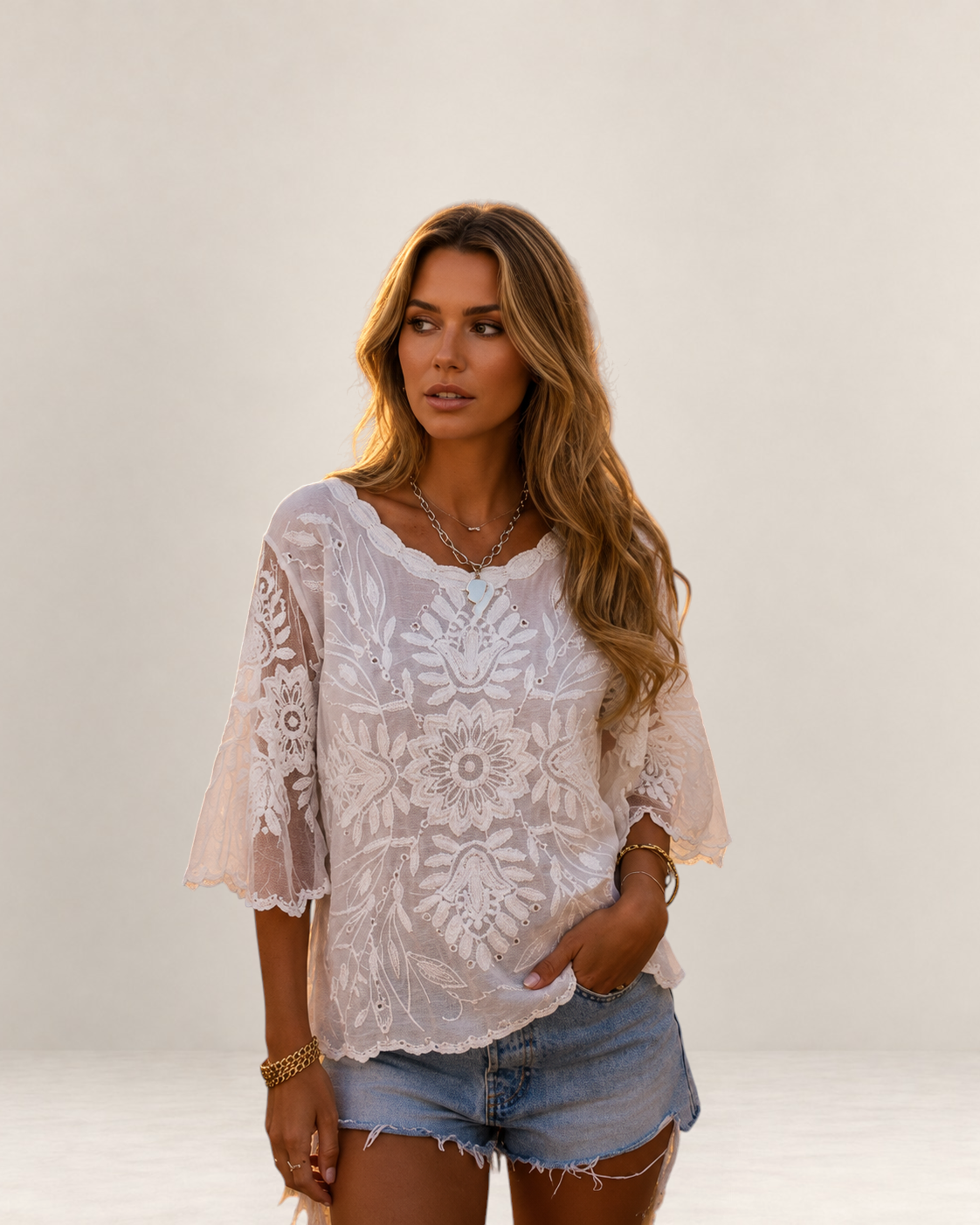 Valvet Oak House Melania white lace blouse with butterfly sleeves worn by a woman on a cobblestone street at sunset
