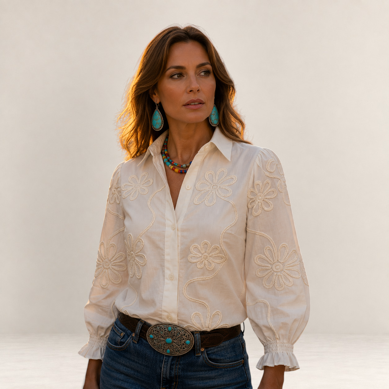 Valvet Oak House Ariane white blouse with raised floral embroidery, worn by a woman in a historic city street.