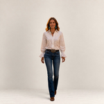 Valvet Oak House Ariane white blouse with floral embroidery worn by a woman walking on a historic Prague street.