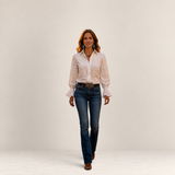 Valvet Oak House Ariane white blouse with floral embroidery worn by a woman walking on a historic Prague street.