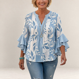Valvet Oak House Agapi blouse in light blue and white with leaf print, V-neck, and tiered ruffled sleeves.