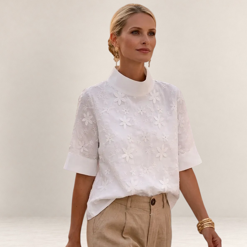 Valvet Oak House Calíope white blouse with floral relief embroidery, high neck, and short sleeves on a model