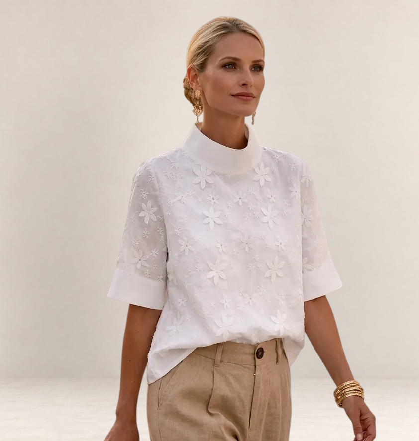 Valvet Oak House Calíope white blouse with floral relief embroidery, high neck, and short sleeves on a model