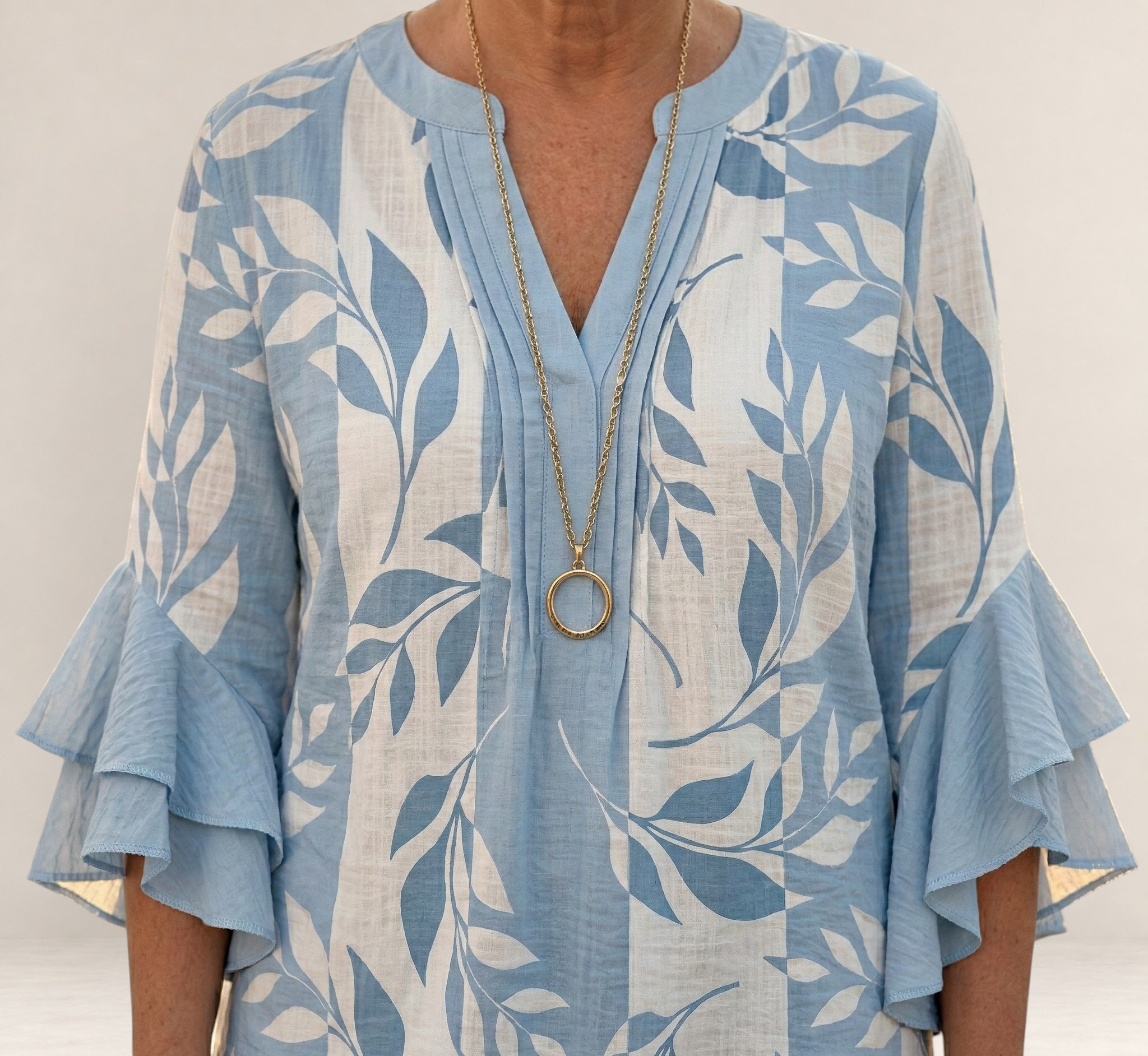 Valvet Oak House Agapi blouse in light blue and white with leaf print, V-neck, and tiered ruffled sleeves.