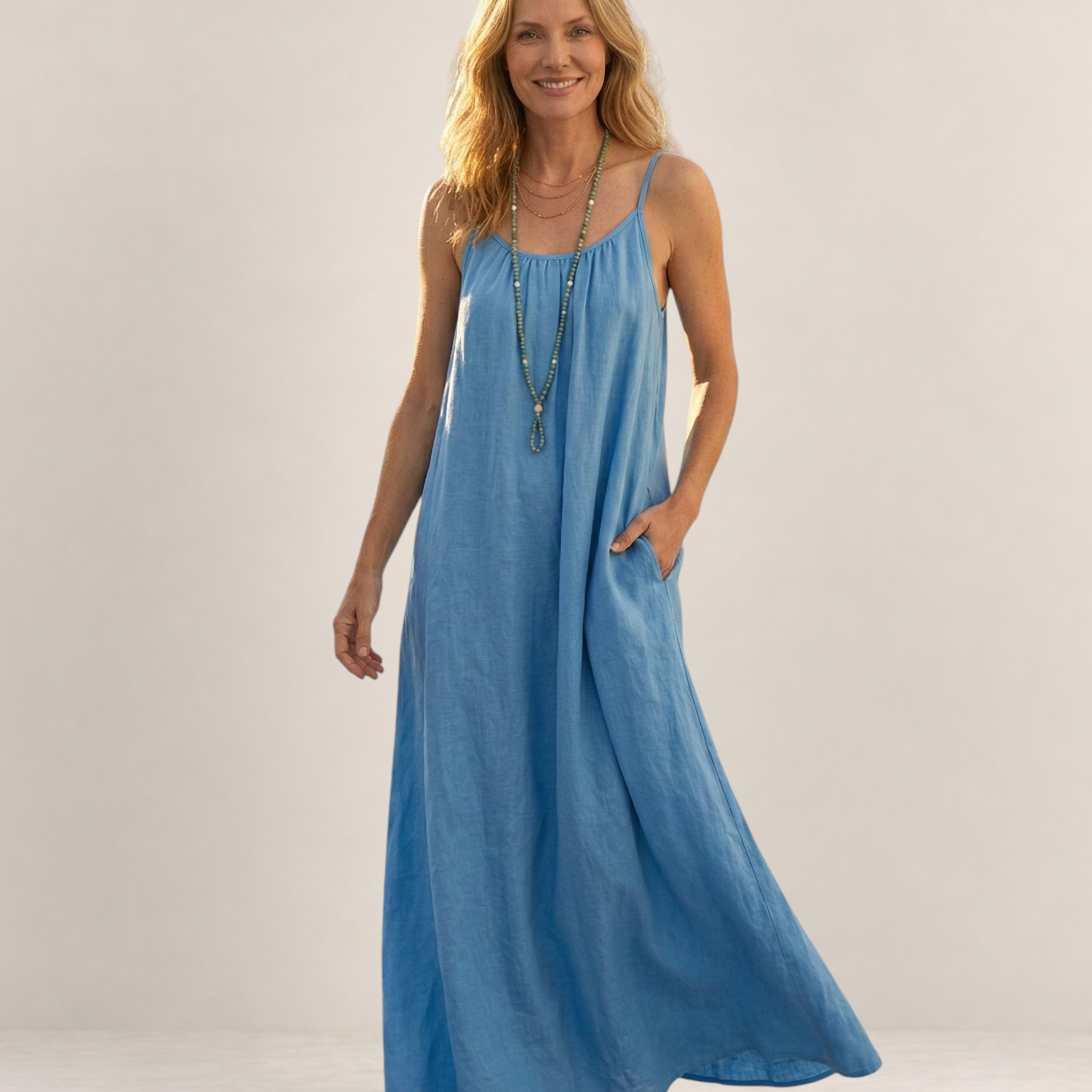 Valvet Oak House Safira blue A-line summer maxi dress with thin straps and pockets worn by a smiling woman